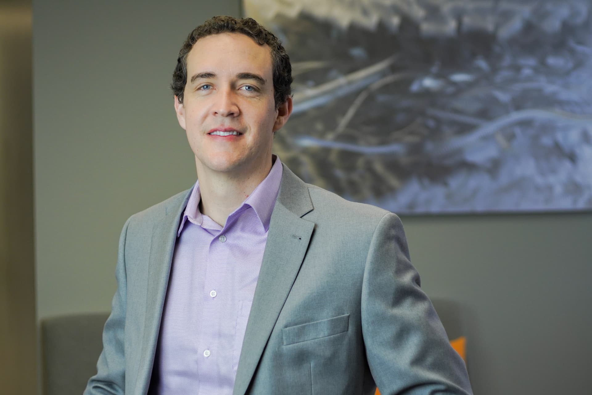 Professional office headshot of a man in a gray suit jacket