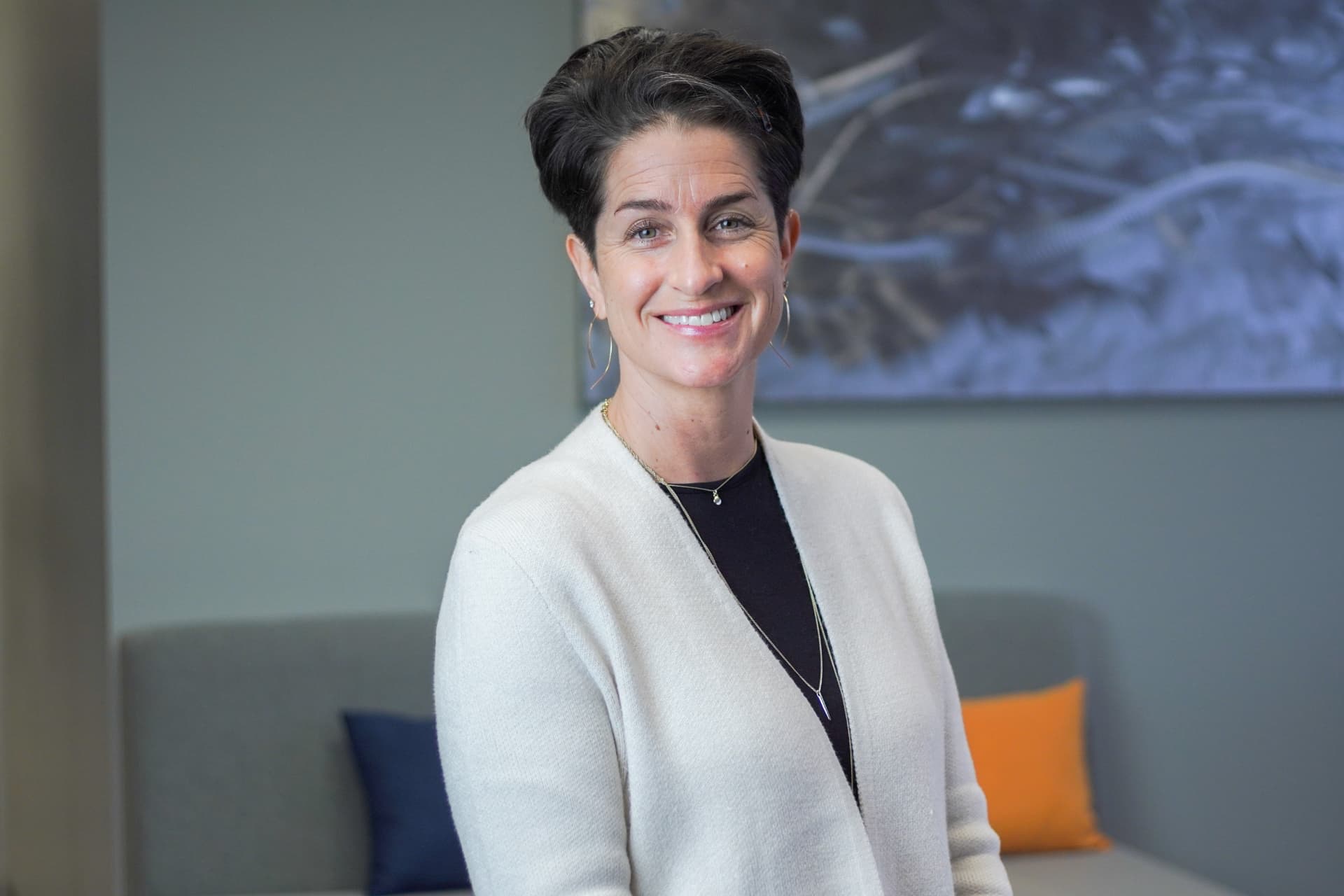 Professional office headshot of a smiling woman in a light cardigan